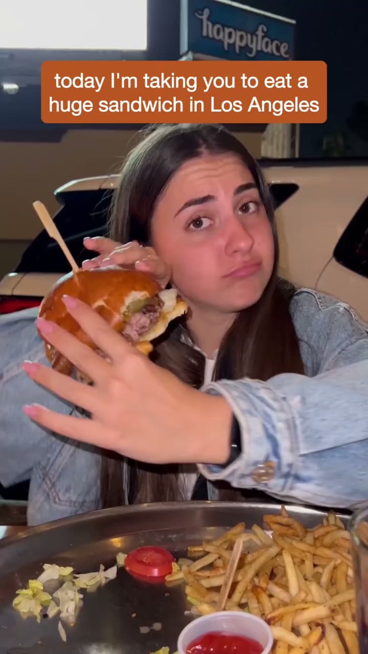 A diner holding a large sandwich