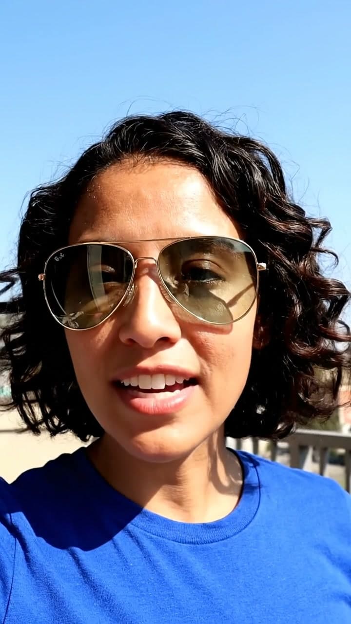 Person styling gold aviator sunglasses